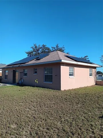 a front view of house with yard and trees in the background