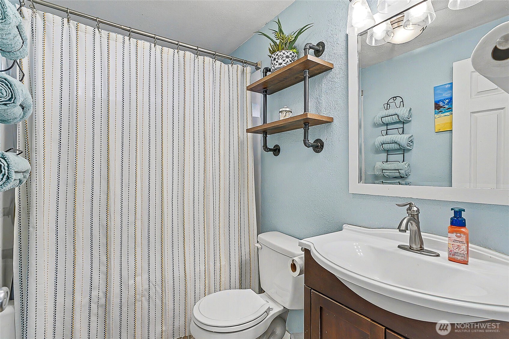 6003 Armour Loop Southeast Olympia, WA 98513 - Photo 21 of 25 a bathroom with a sink a toilet and shower curtain