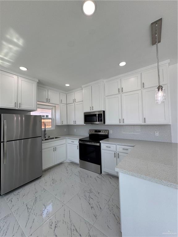 2101 Selena Street, Unit 1 Mission, TX 78572 - Photo 6 of 18 a kitchen with stainless steel appliances granite countertop a refrigerator sink and cabinets