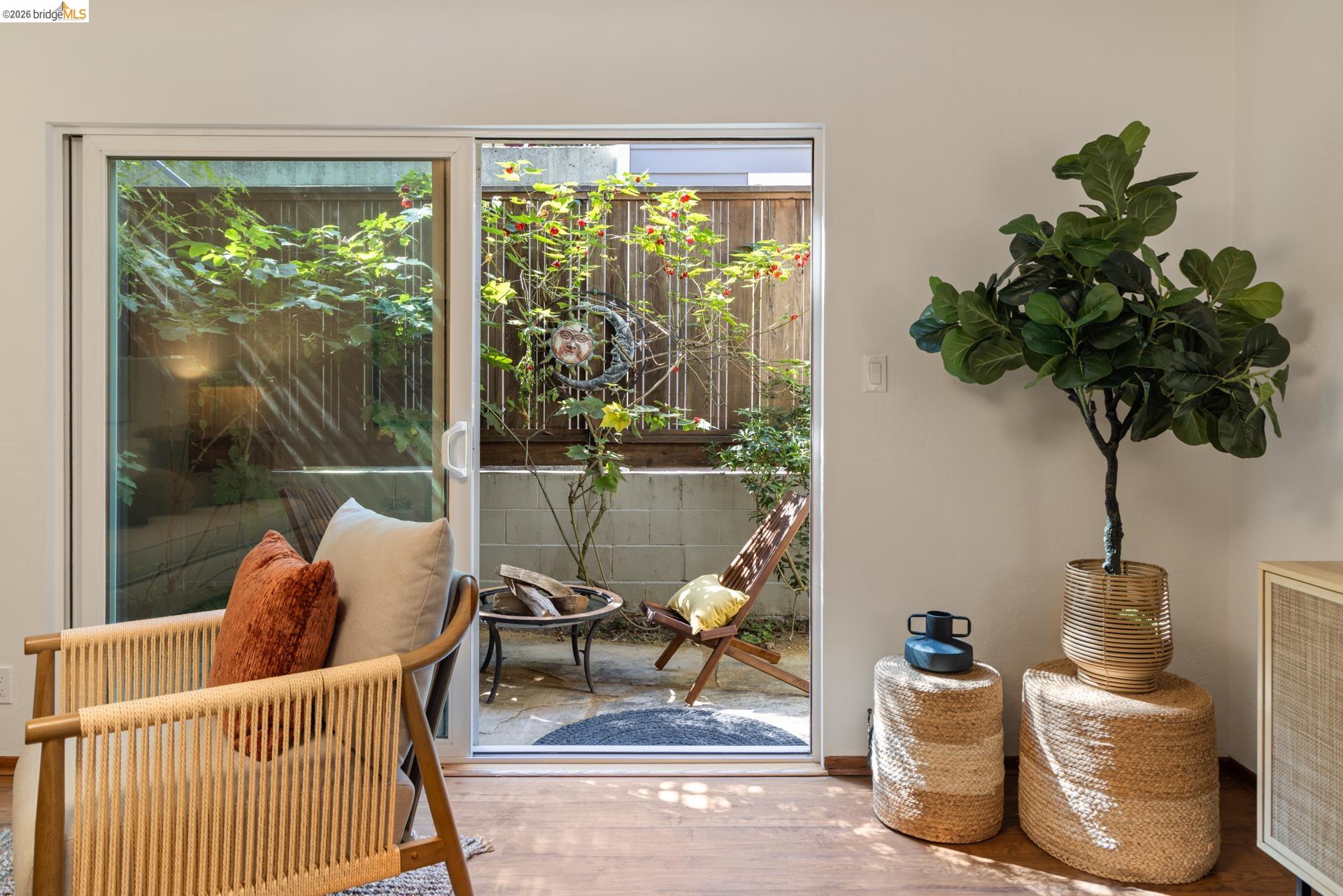 6660 Sobrante Road Oakland, CA 94611 - Photo 18 of 48 Sliding glass door leading to a private outdoor patio with a concrete block wall and wood fencing