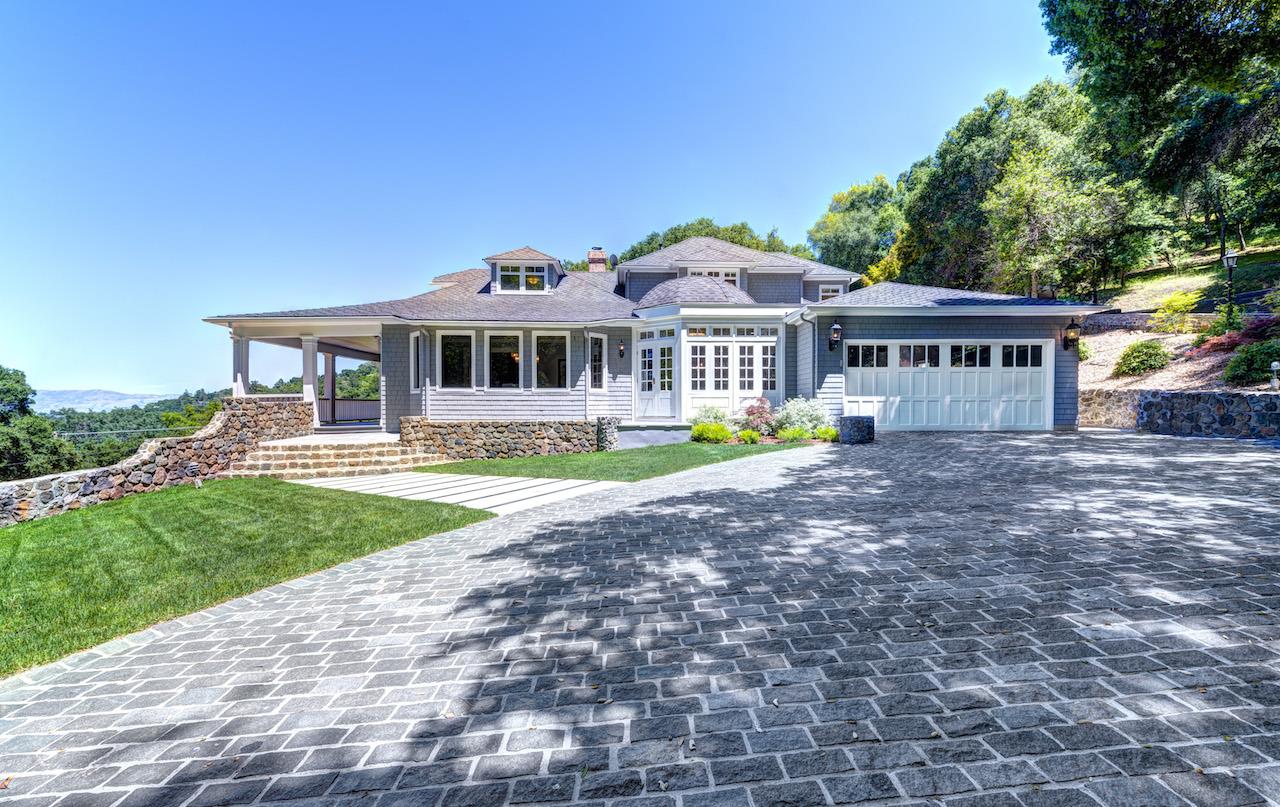 a front view of a house with a garden and trees