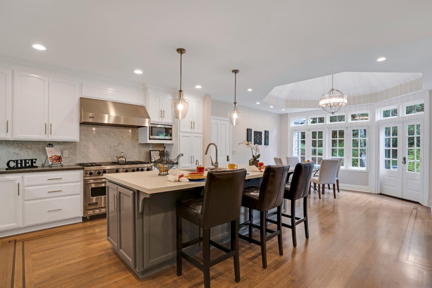 17915 Foster Road Los Gatos, CA 95030 - Photo 9 of 30 a kitchen with stainless steel appliances granite countertop a stove a refrigerator a kitchen island a dining table and chairs with wooden floor