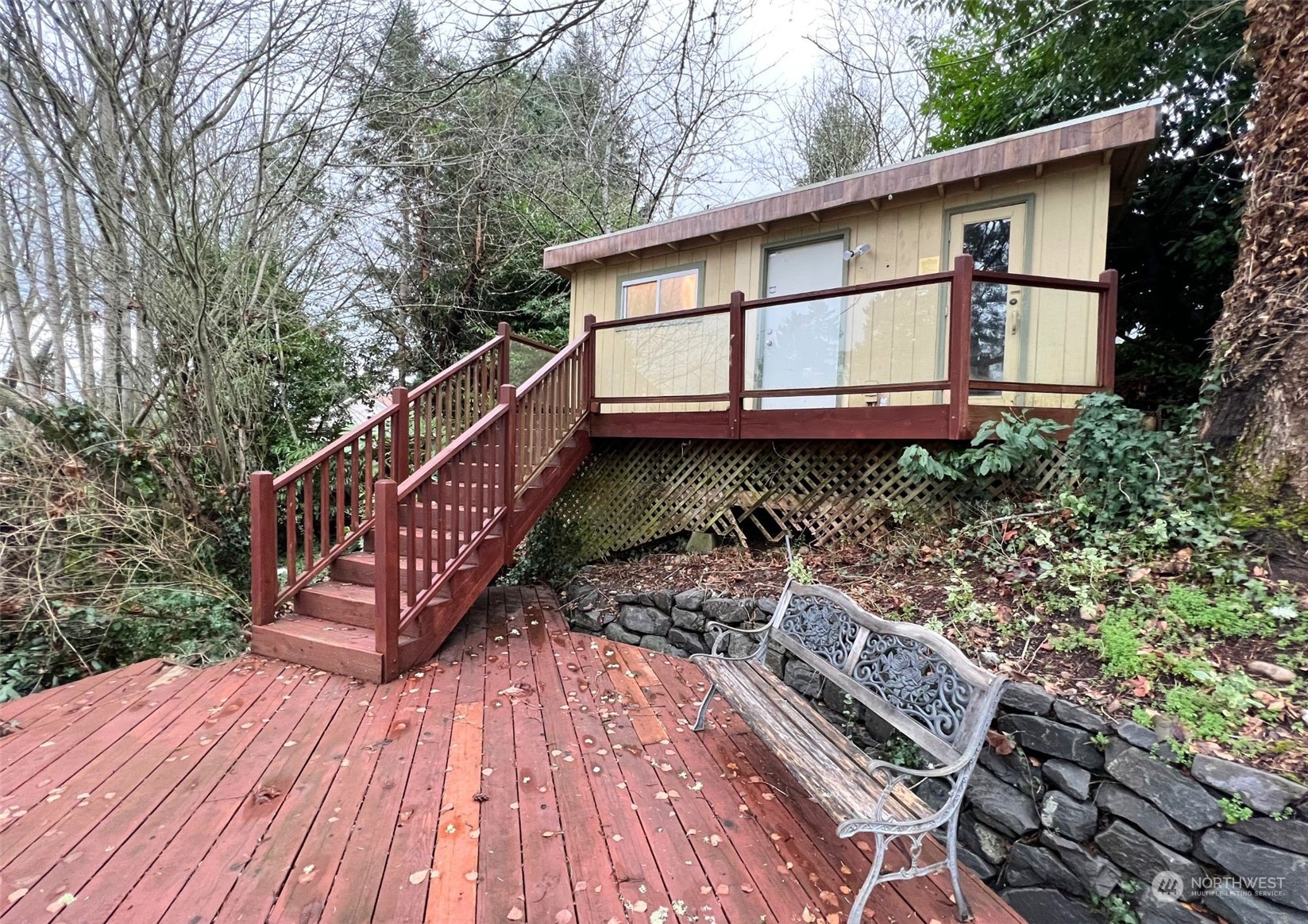 913 Powell Street Steilacoom, WA 98388 - Photo 21 of 40 a wooden deck with trees in front of it