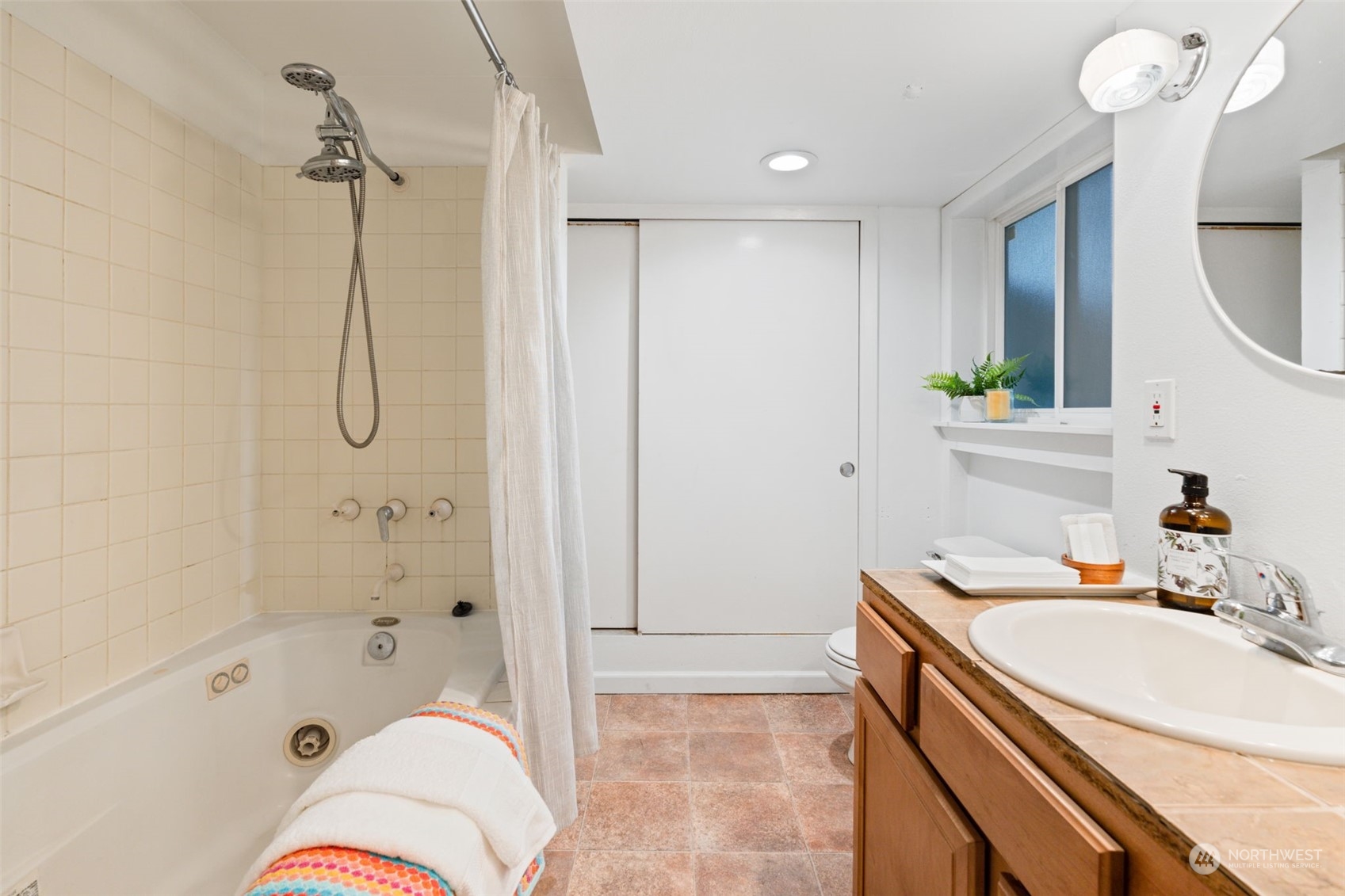 913 Powell Street Steilacoom, WA 98388 - Photo 29 of 40 a bathroom with a sink a vanity a mirror and a bathtub