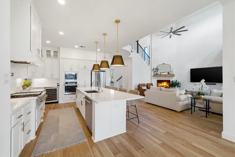 a kitchen with stainless steel appliances a stove top oven a sink a counter space and wooden floor