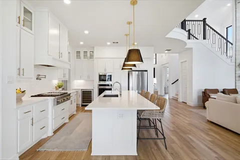 a kitchen with stainless steel appliances kitchen island granite countertop a stove a sink a dining table and chairs