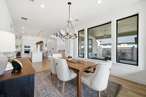 a dining room with furniture a chandelier and wooden floor