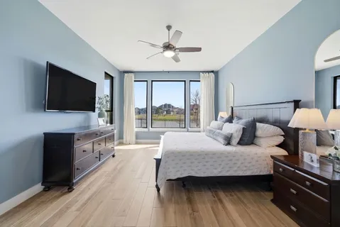 a bedroom with a bed and a flat screen tv on dresser