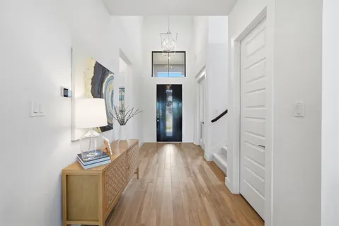 a view of a hallway with wooden floor and entryway