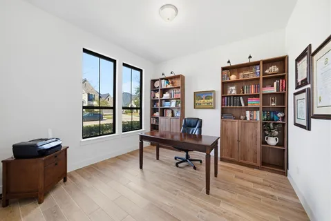 a view of a workspace with furniture and a bookshelf
