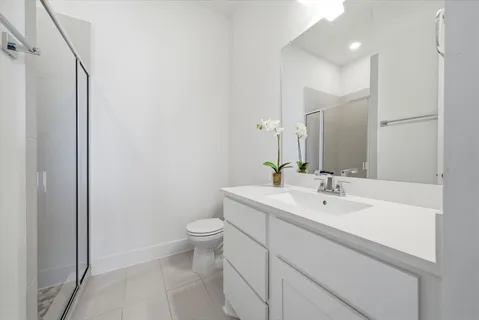 a bathroom with a sink a toilet and a large mirror