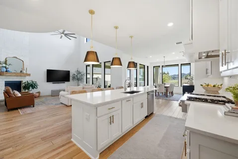 a kitchen with counter top space and living room view