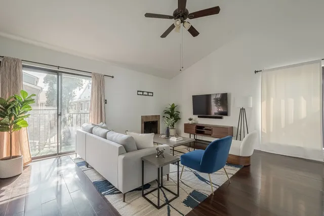 a living room with furniture a flat screen tv and a window