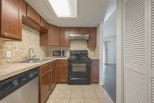 a kitchen with stainless steel appliances granite countertop a stove a sink and a refrigerator