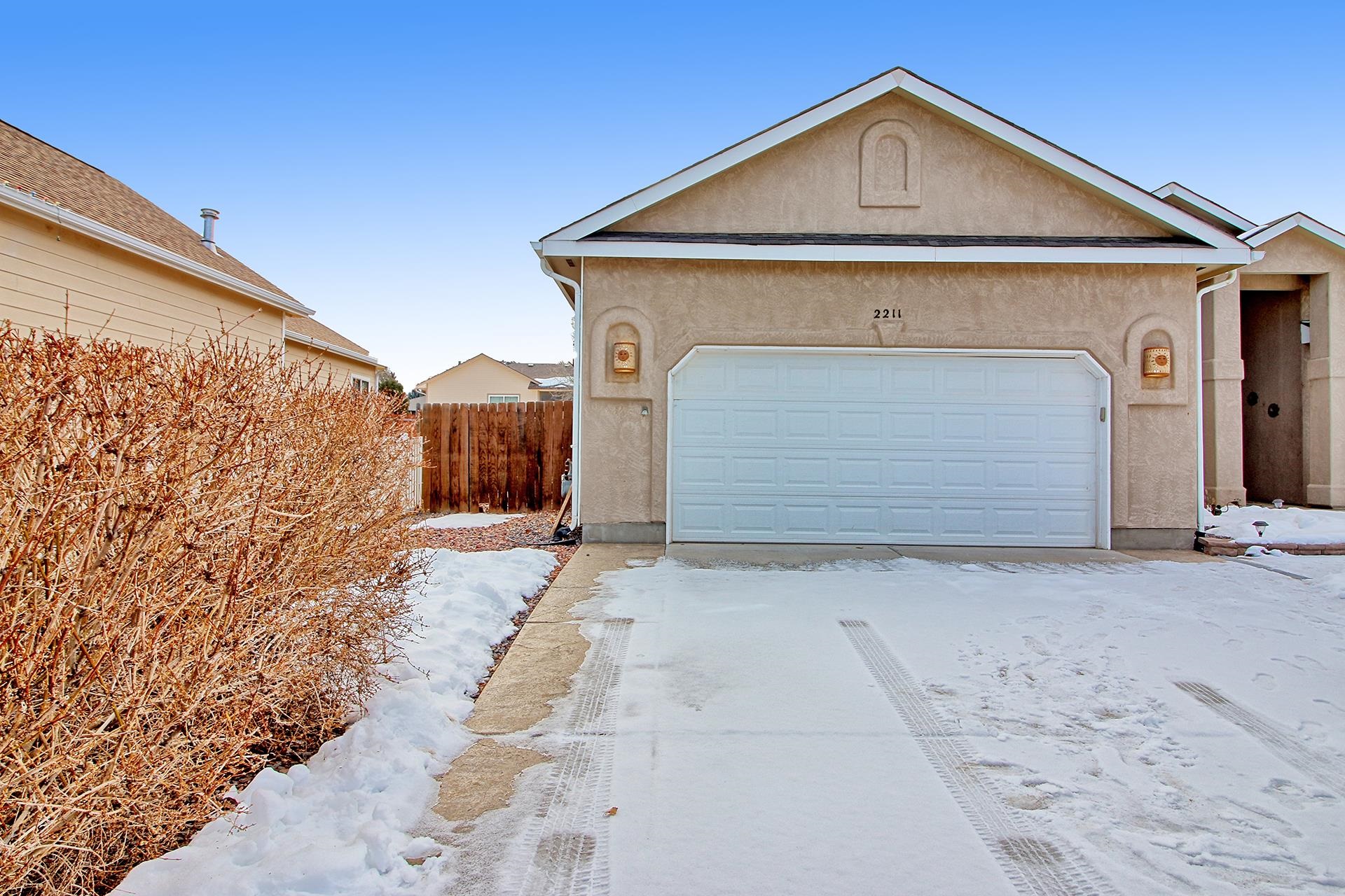 2211 Victorian Court Grand Junction, CO 81507 - Photo 18 of 42 a front view of a house with a yard and garage