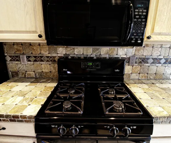 a stove top oven sitting inside of a kitchen