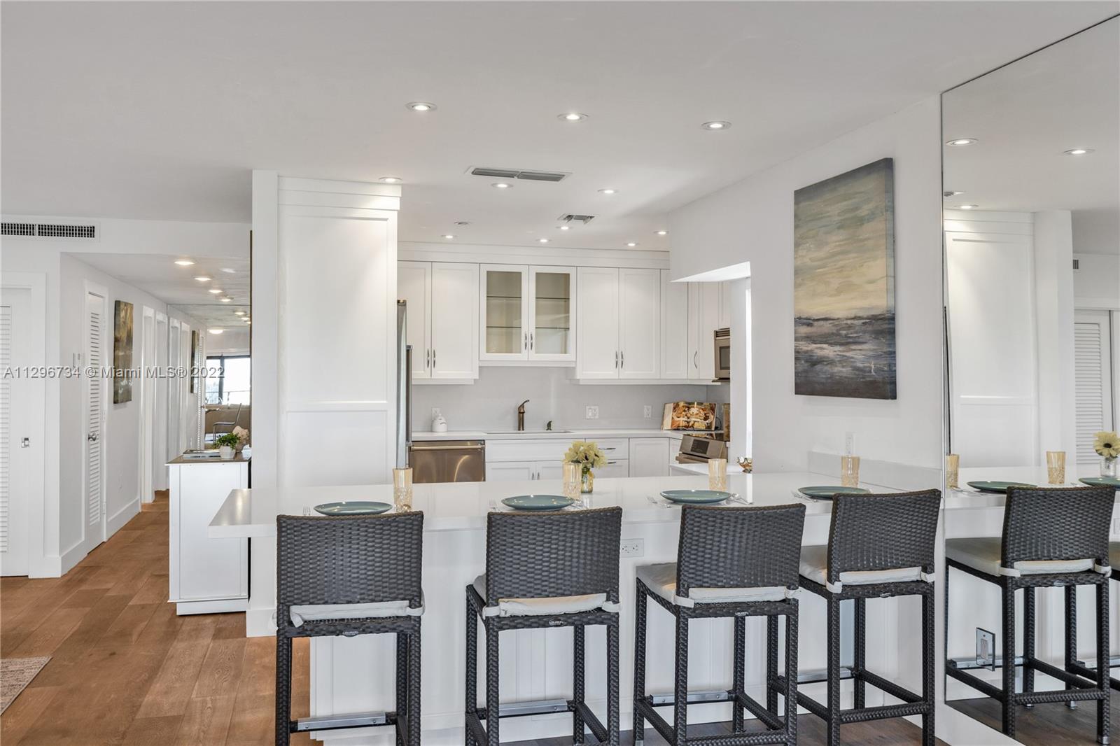 166 Harbor Drive, Unit 1A Key Biscayne, FL 33149 - Photo 18 of 86 a dining room with stainless steel appliances kitchen island granite countertop a dining table chairs and a refrigerator