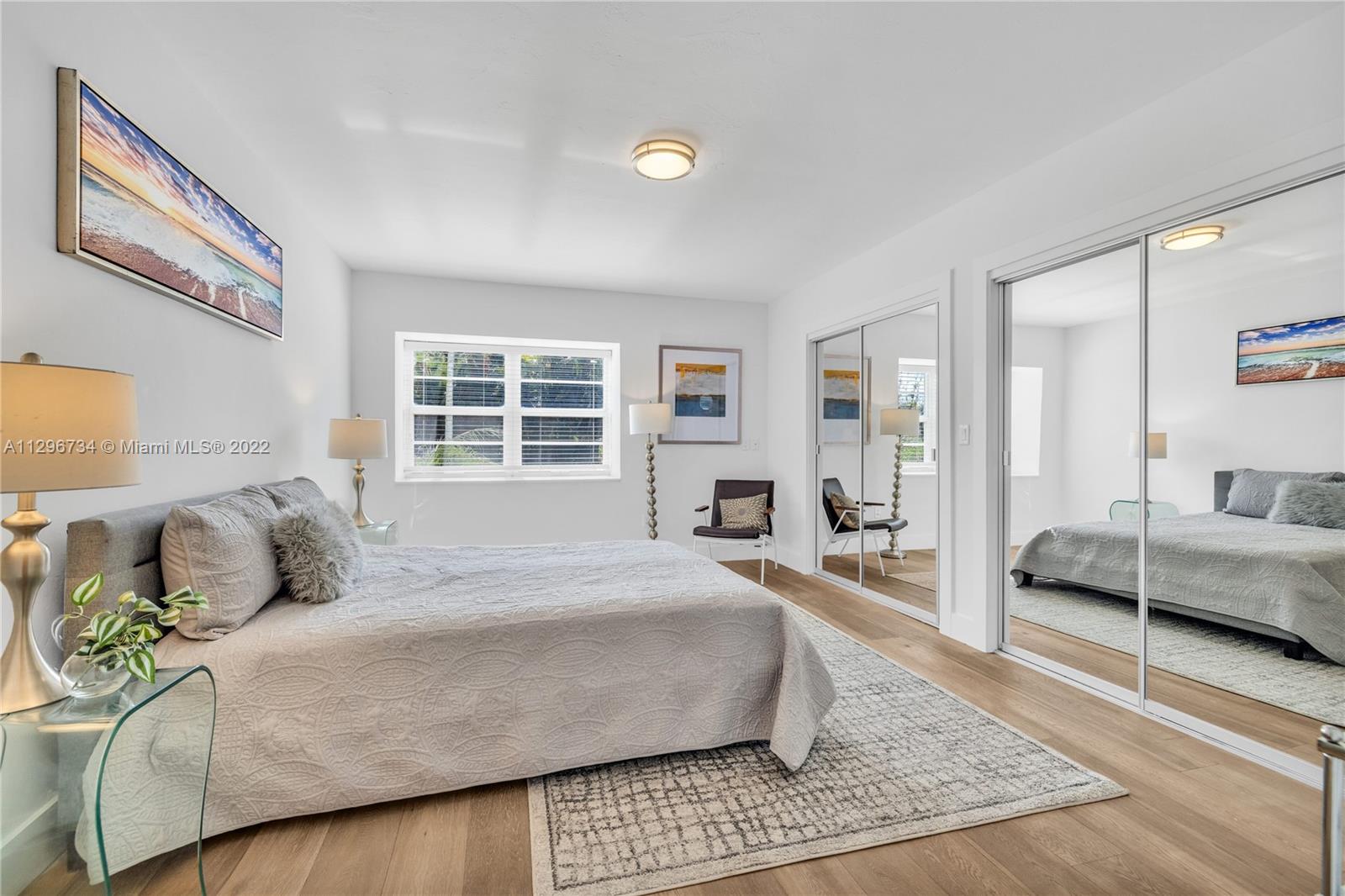 166 Harbor Drive, Unit 1A Key Biscayne, FL 33149 - Photo 29 of 86 a bedroom with a large bed a couch and a window