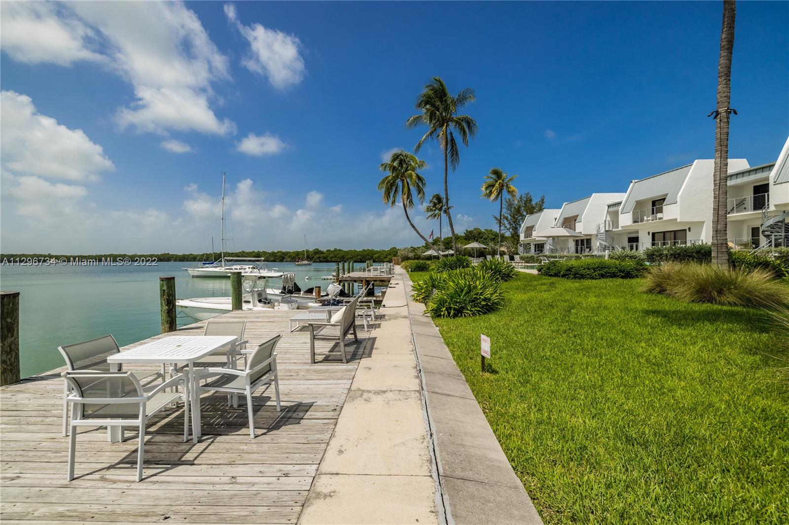 166 Harbor Drive, Unit 1A Key Biscayne, FL 33149 - Photo 64 of 86 a view of a patio with couches and a table and chairs with wooden floor