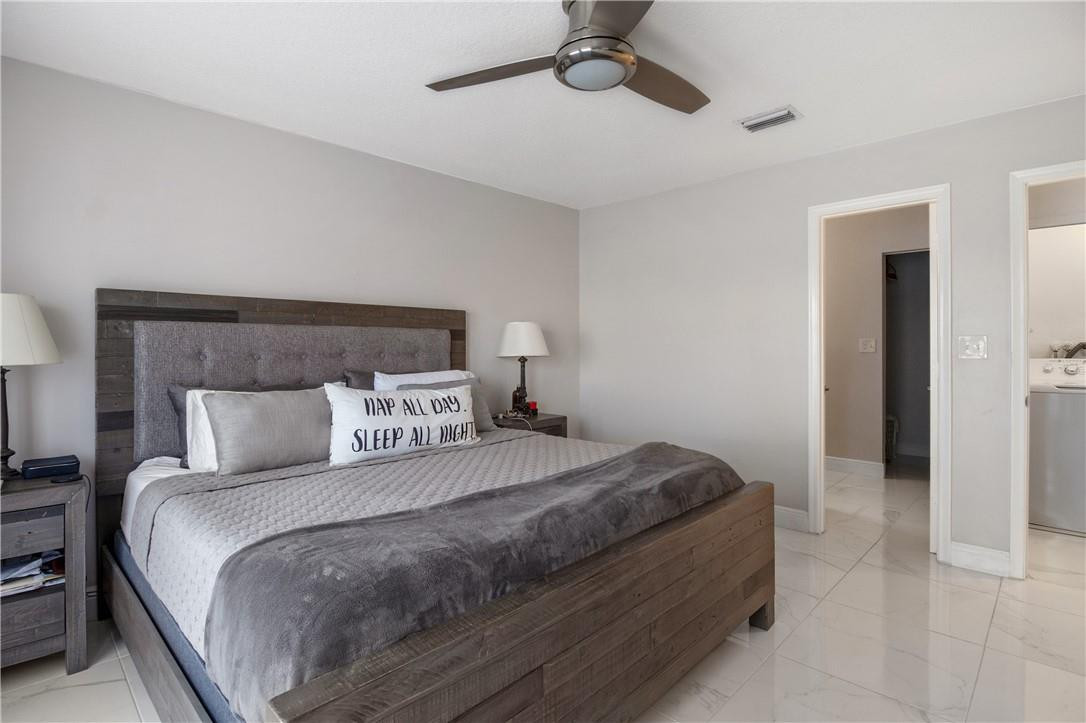 727 Banks Road, Unit 98 Margate, FL 33063 - Photo 13 of 22 a bedroom with a bed and a chandelier