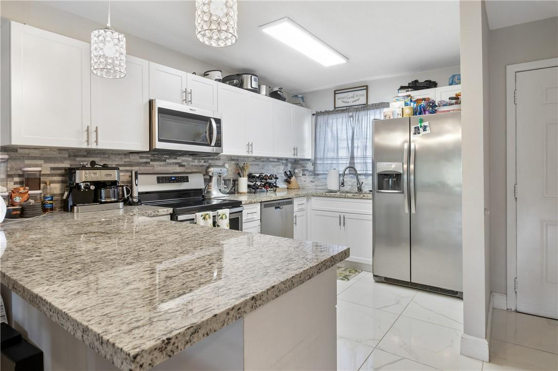 727 Banks Road, Unit 98 Margate, FL 33063 - Photo 10 of 22 a kitchen with stainless steel appliances granite countertop a sink stove and refrigerator