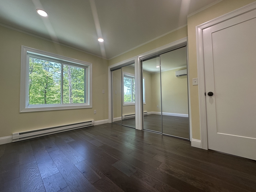 102 Wells Road Becket, MA 01223 - Photo 18 of 40 an empty room with wooden floor and windows