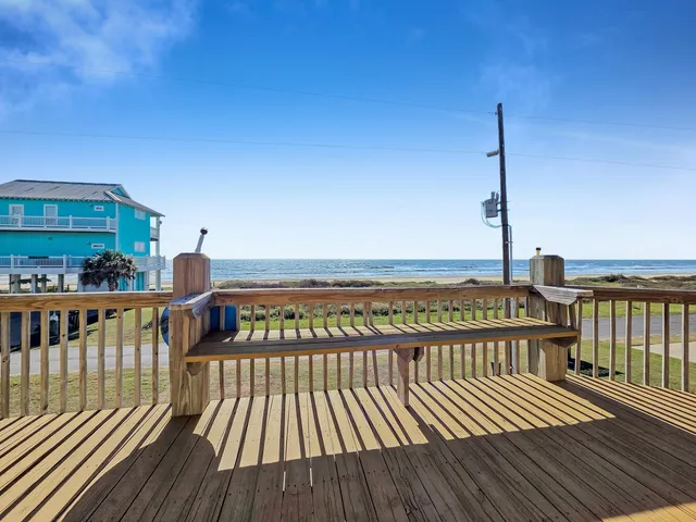 a living room with furniture kitchen view and a wooden floor