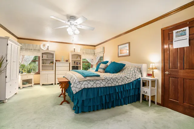 a bedroom with a bed dresser and a large window