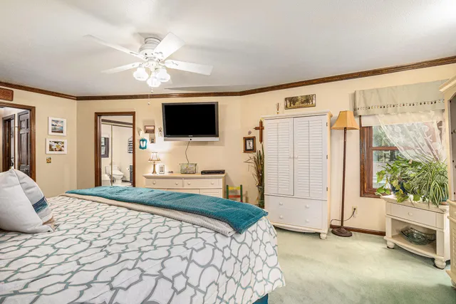 a bedroom with a large bed and a flat tv screen