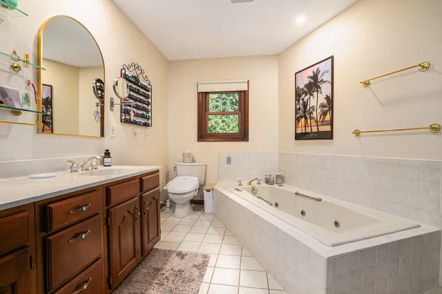 a bathroom with a tub sink and mirror