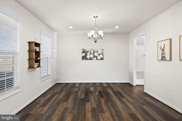 a spacious bedroom with a bed window and a chandelier