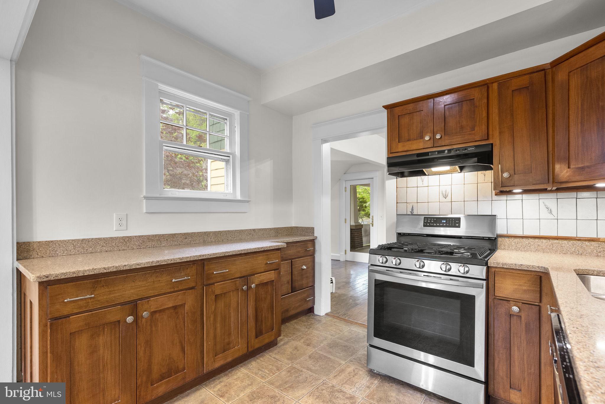 9120 Glenridge Road Silver Spring, MD 20910 - Photo 14 of 59 a kitchen with granite countertop wooden cabinets stainless steel appliances and a window