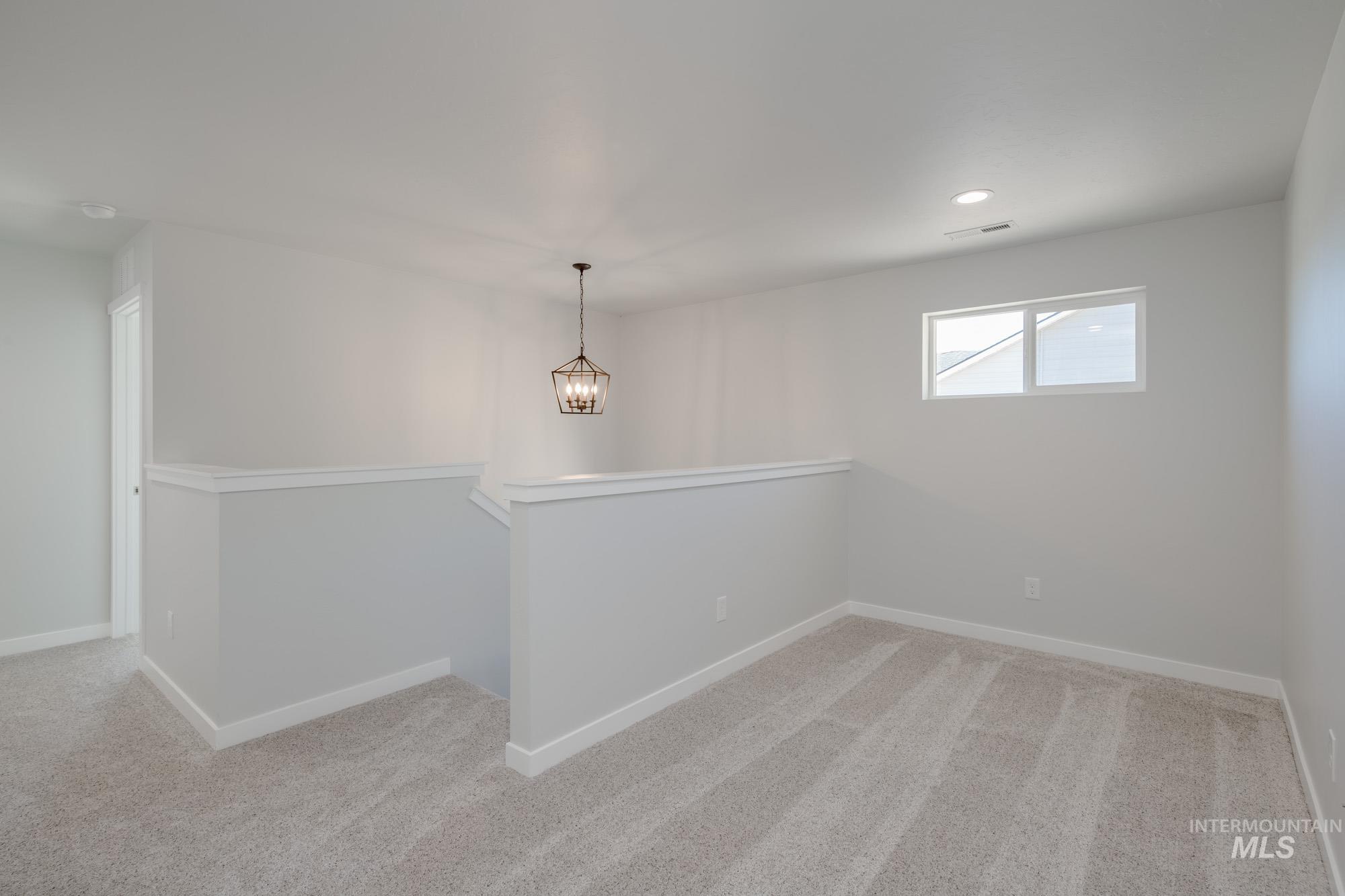 13699 Judson Street Caldwell, ID 83607 - Photo 22 of 26 Spare room with light colored carpet, a chandelier, and recessed lighting