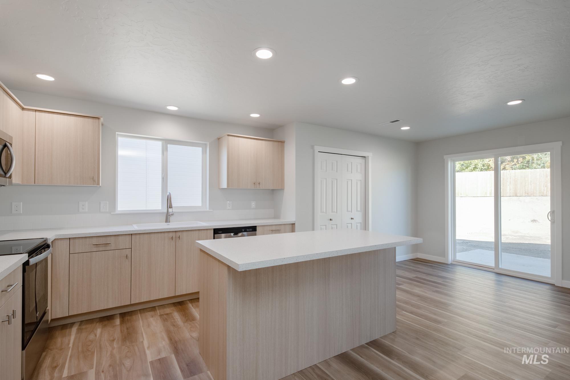 13699 Judson Street Caldwell, ID 83607 - Photo 7 of 26 Kitchen featuring light brown cabinetry, light countertops, appliances with stainless steel finishes, light wood-type flooring, and recessed lighting