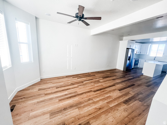 522 West 2000 South Vernal, UT 84078 - Photo 16 of 18 Unfurnished living room featuring dark wood-type flooring, a ceiling fan, and beam ceiling