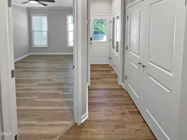 a view of an empty room with wooden floor and a window