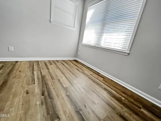 a kitchen with stainless steel appliances granite countertop a sink dishwasher a refrigerator and a stove with wooden floor