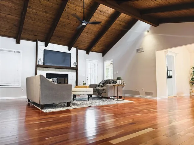 a living room with furniture a fireplace and a flat screen tv