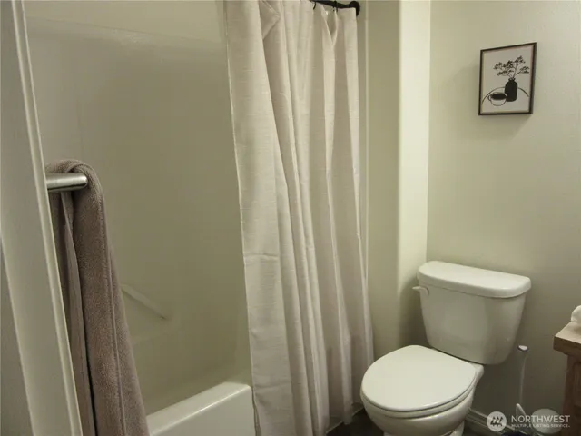 a white toilet sitting next to a shower