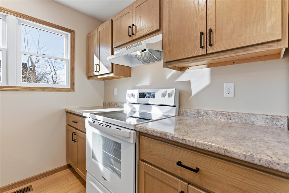 313 East Martin Street Forrest, IL 61741 - Photo 12 of 50 a kitchen with stainless steel appliances granite countertop white cabinets and a stove