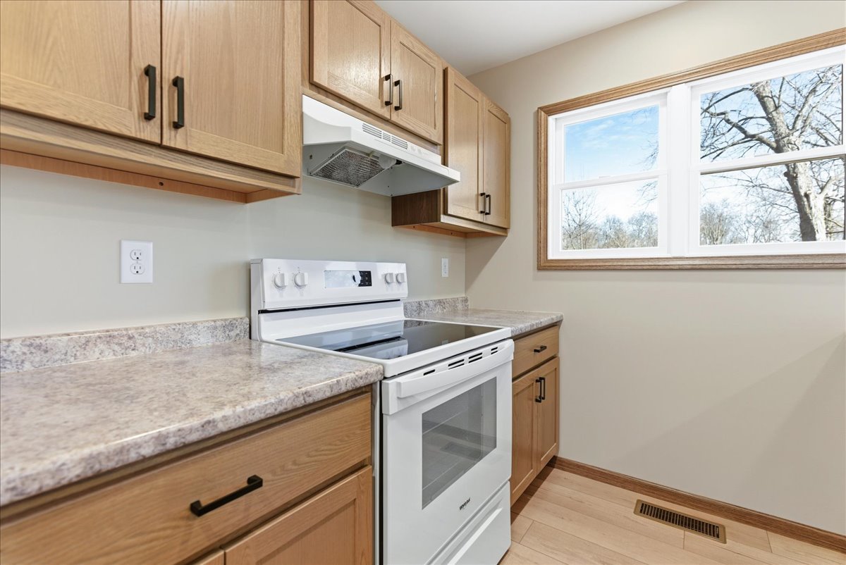 313 East Martin Street Forrest, IL 61741 - Photo 35 of 50 a kitchen with granite countertop cabinets stainless steel appliances and a wooden floor