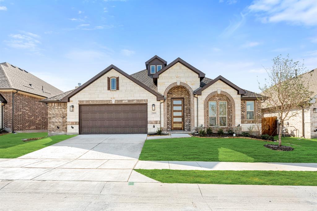 a front view of a house with a yard and garage