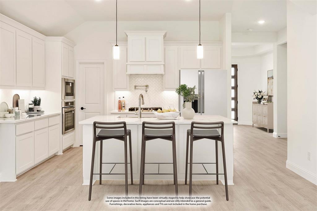 2009 Ambergate Drive Anna, TX 75409 - Photo 12 of 36 a kitchen with stainless steel appliances kitchen island a table chairs sink and cabinets