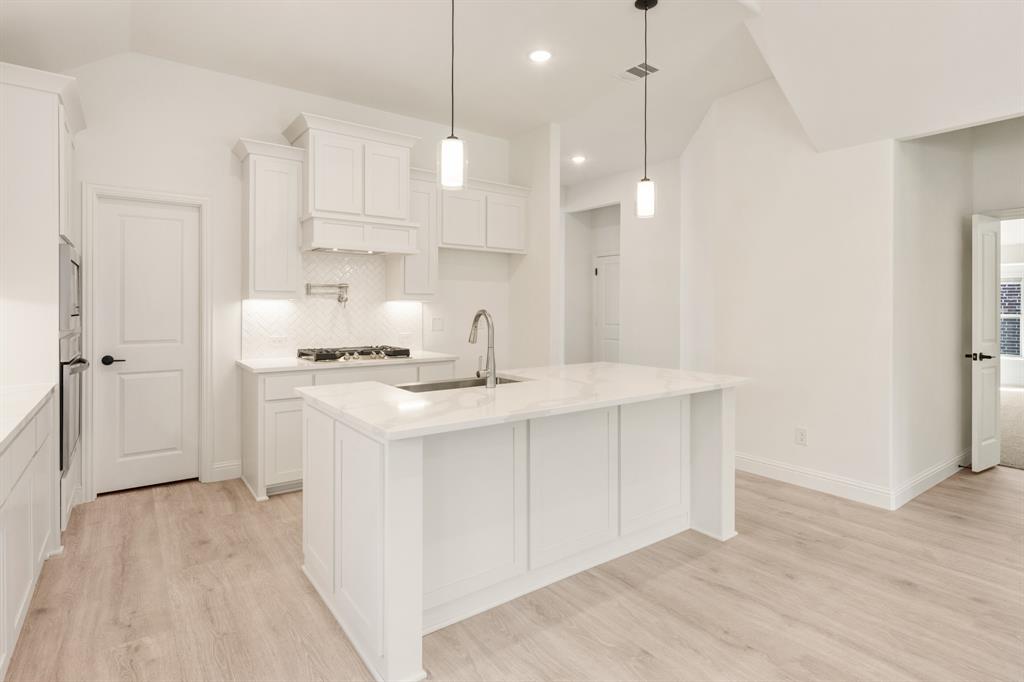 2009 Ambergate Drive Anna, TX 75409 - Photo 13 of 36 a kitchen with kitchen island a sink stainless steel appliances and cabinets