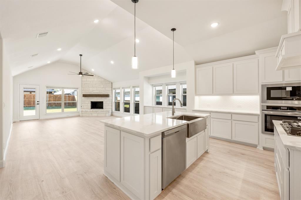 2009 Ambergate Drive Anna, TX 75409 - Photo 9 of 36 a kitchen with kitchen island a sink a counter top space stainless steel appliances and cabinets