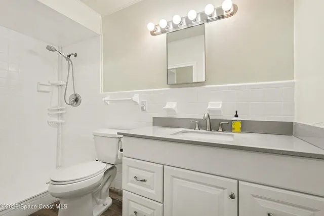 a bathroom with a sink a toilet and mirror