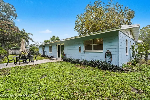 a backyard of a house with table and chairs