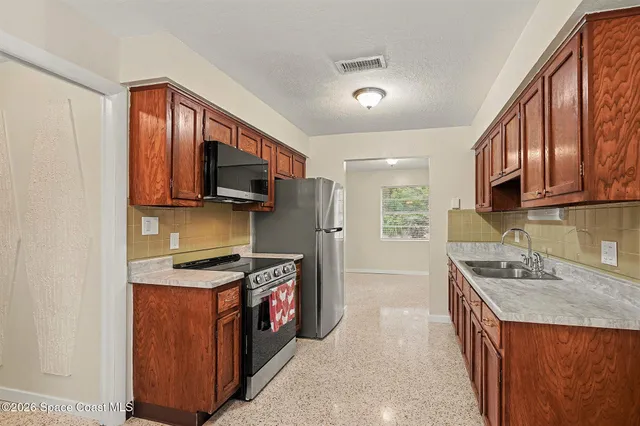 a kitchen with stainless steel appliances granite countertop a stove top oven a sink dishwasher and a microwave oven on the blue kitchen countertops