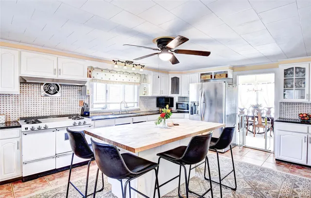 a kitchen with stainless steel appliances kitchen island granite countertop a dining table and chairs