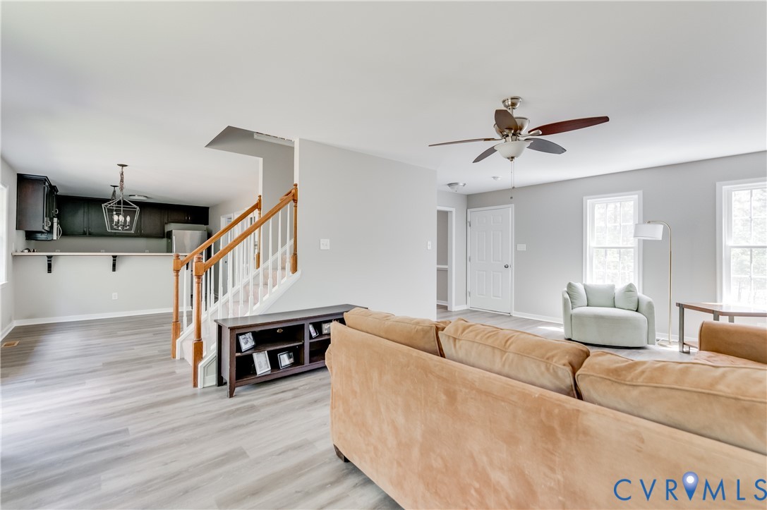 6320 Walnut Tree Drive Powhatan, VA 23139 - Photo 4 of 34 Living area with a chandelier, stairway, light woo